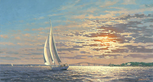 Sailboat on water with a bridge and sunset in the background